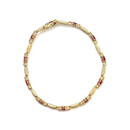 Top-down view of a yellow metal bracelet with alternating oval red gemstones and smooth metal links, accented with small white round gemstones in prong settings.