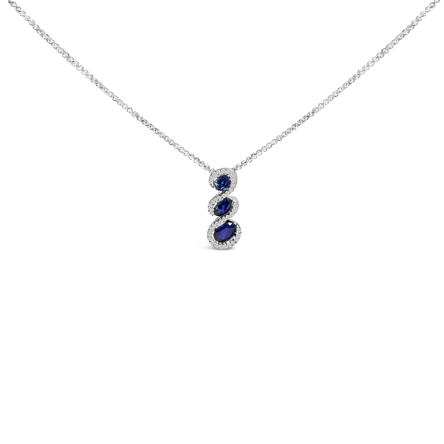 Front-facing view of a white metal necklace with a vertical pendant featuring three oval blue gemstones, each surrounded by small round white gemstones, shown on a white background.