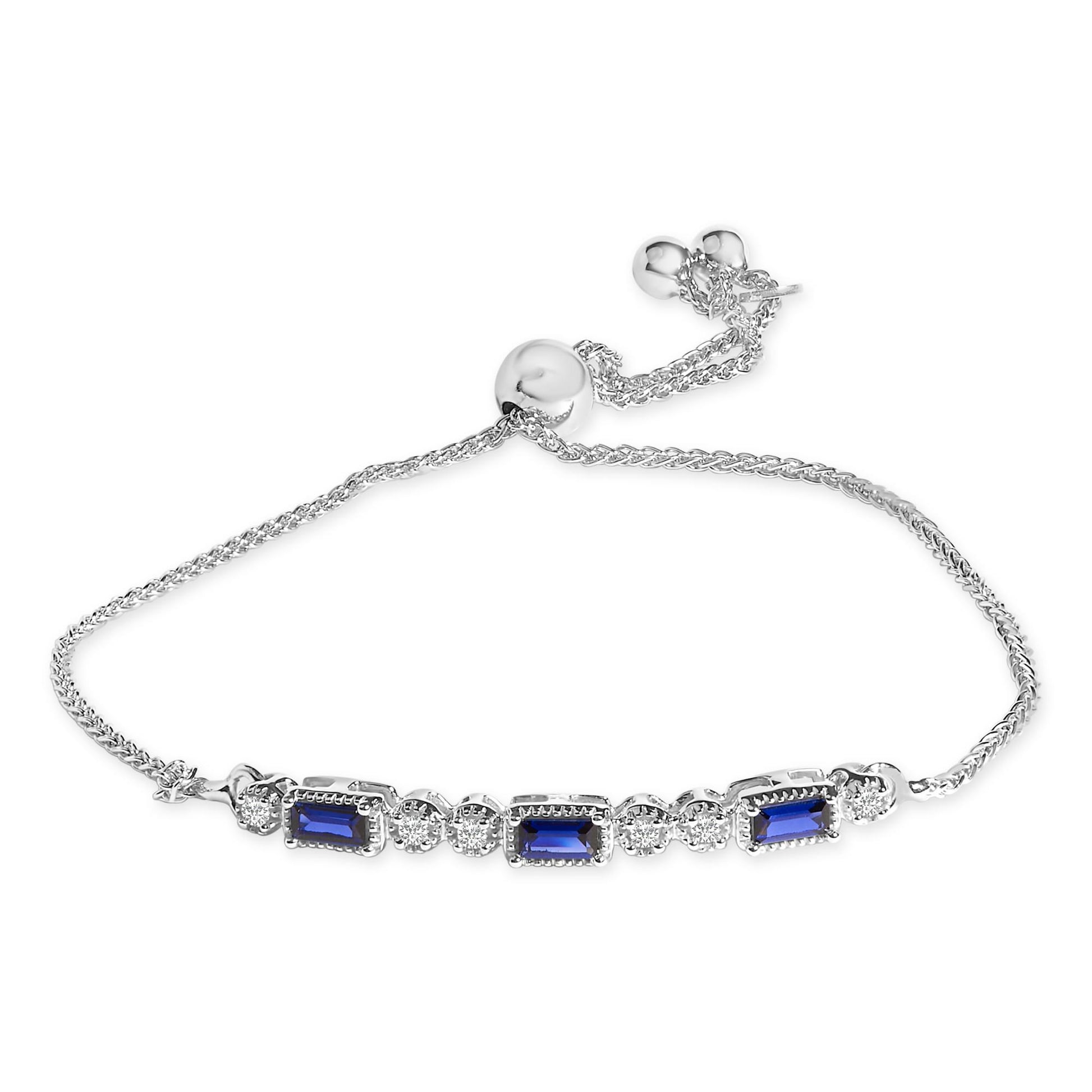 White metal bracelet with alternating blue baguette-shaped gemstones and white round gemstones, shown in a top-down view.
