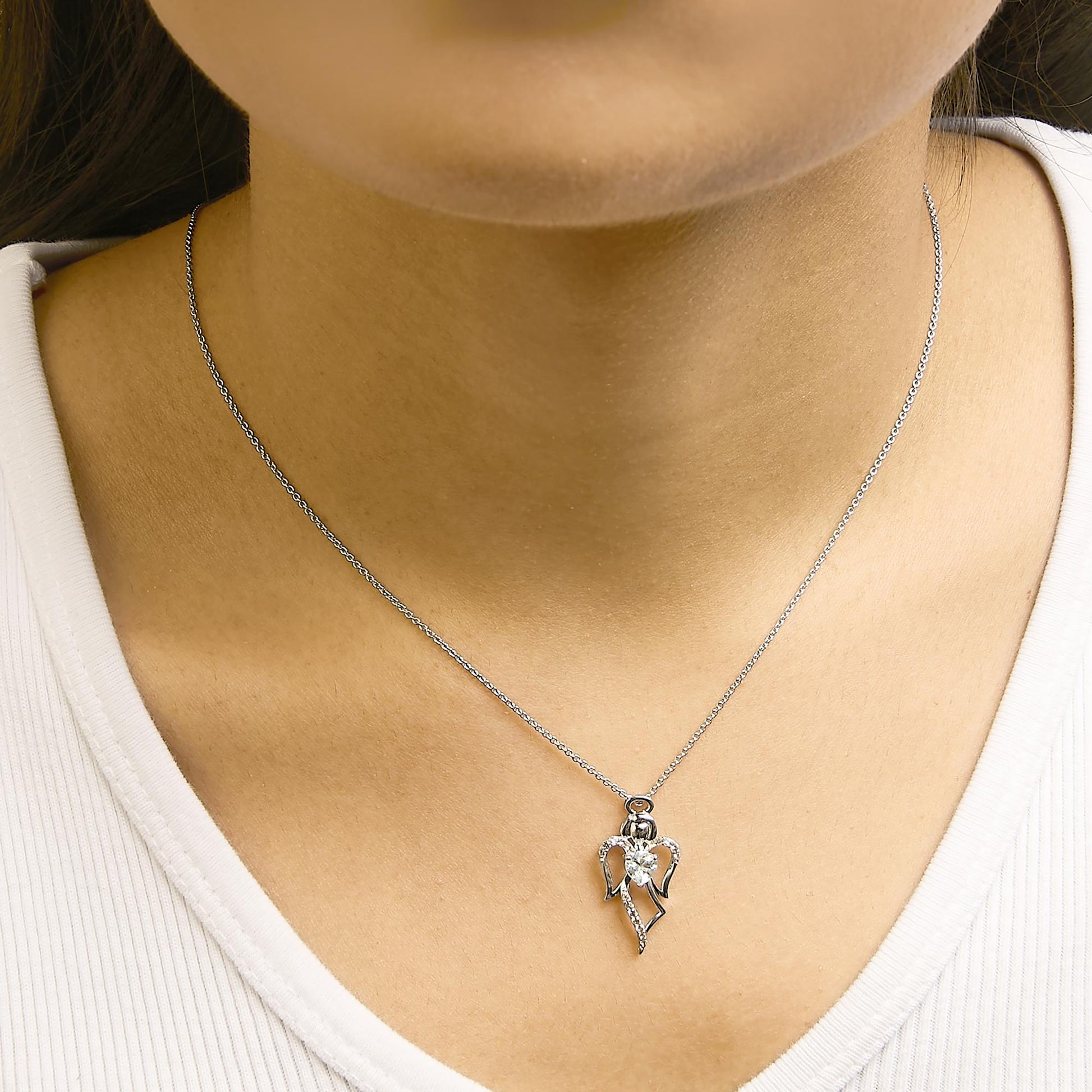 White necklace with a heart-shaped blue gemstone center pendant surrounded by white round gemstones, shown worn on a model, front view.