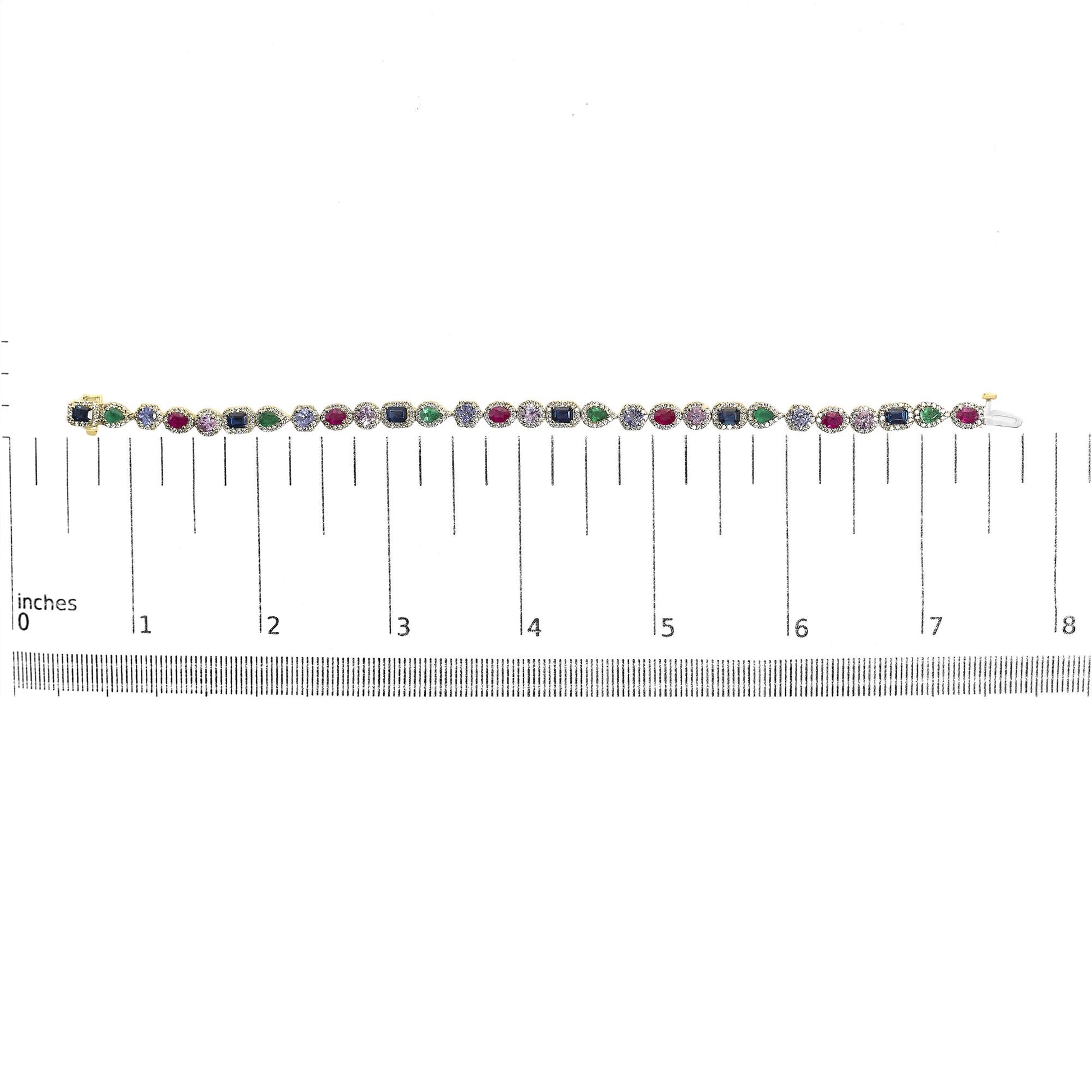 Yellow metal bracelet with a pattern of pear-shaped green gemstones, oval red gemstones, round pink and blue gemstones, emerald-shaped blue gemstones, and round white gemstones in prong settings, shown on a scale from overhead angle.
