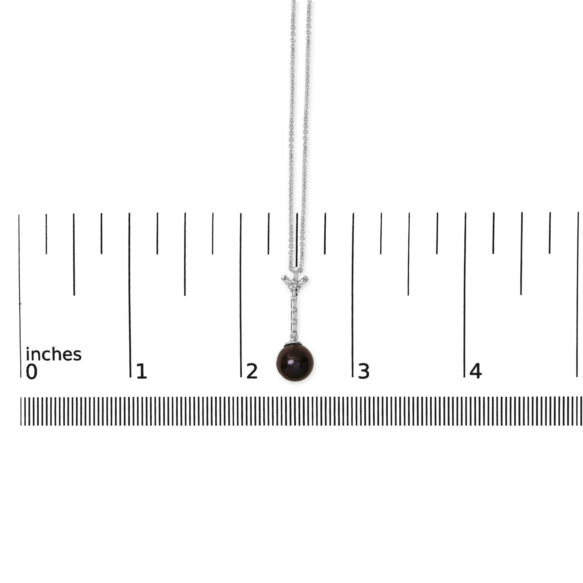 White metal necklace shown on a scale, featuring a pendant with a vertical row of six white baguette-shaped gemstones in channel settings, topped with a Y-shaped arrangement of gemstones, and a round dark gemstone hanging at the bottom, displayed from a front angle.