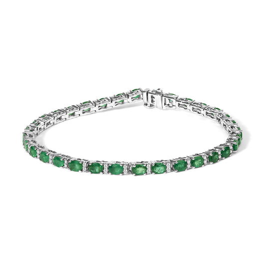 White bracelet with oval green gemstones and round white gemstones in prong settings, shown from a front angled view.