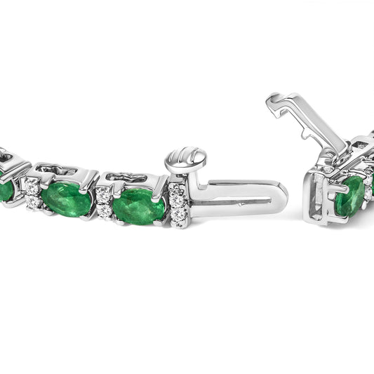 Close-up angled view of a white metal bracelet with oval green gemstones and round white gemstones, shown open on a white background.