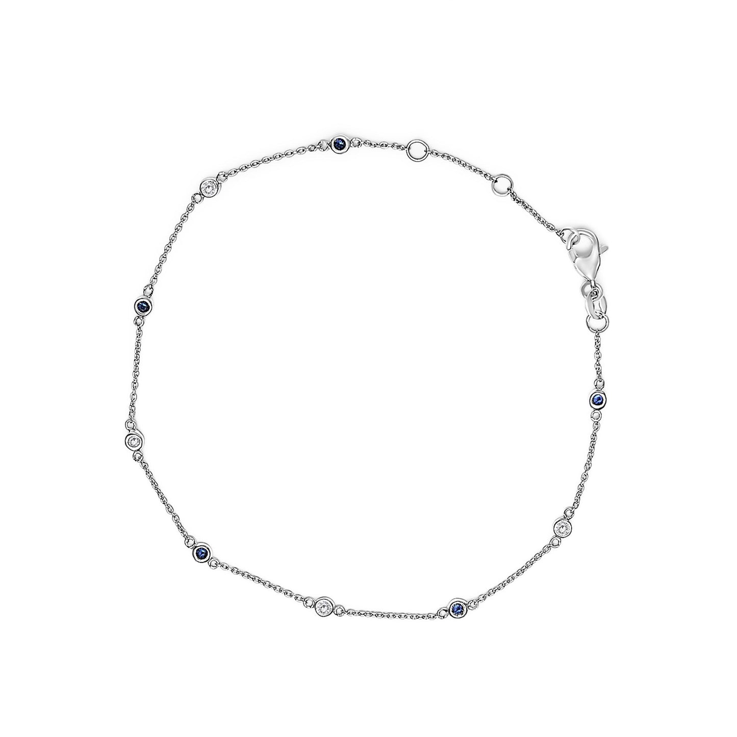 Top-down view of a white metal bracelet with alternating round bezel-set white and blue gemstones.