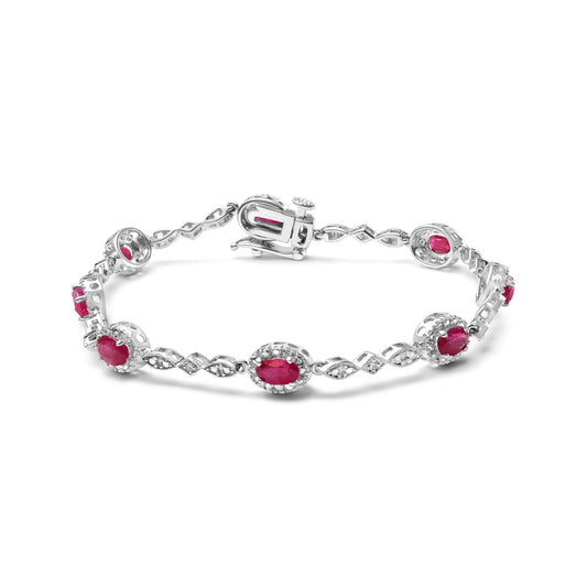 White metal bracelet with alternating oval red gemstones and decorative links with small white round gemstones, shown from a slightly elevated angle.