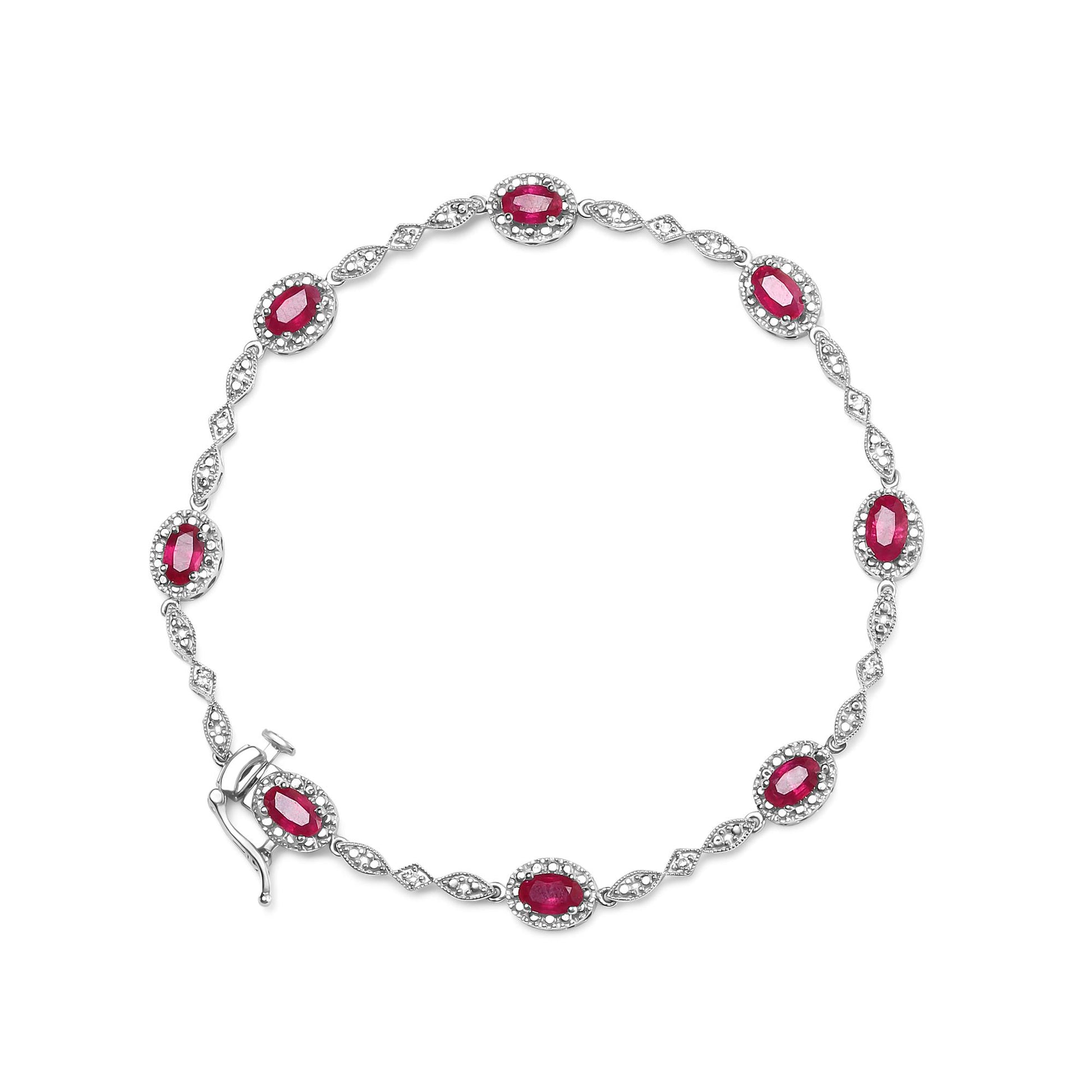 Top-down view of white metal bracelet with alternating oval red gemstones surrounded by small white gemstones and marquise-shaped links with white gemstones.