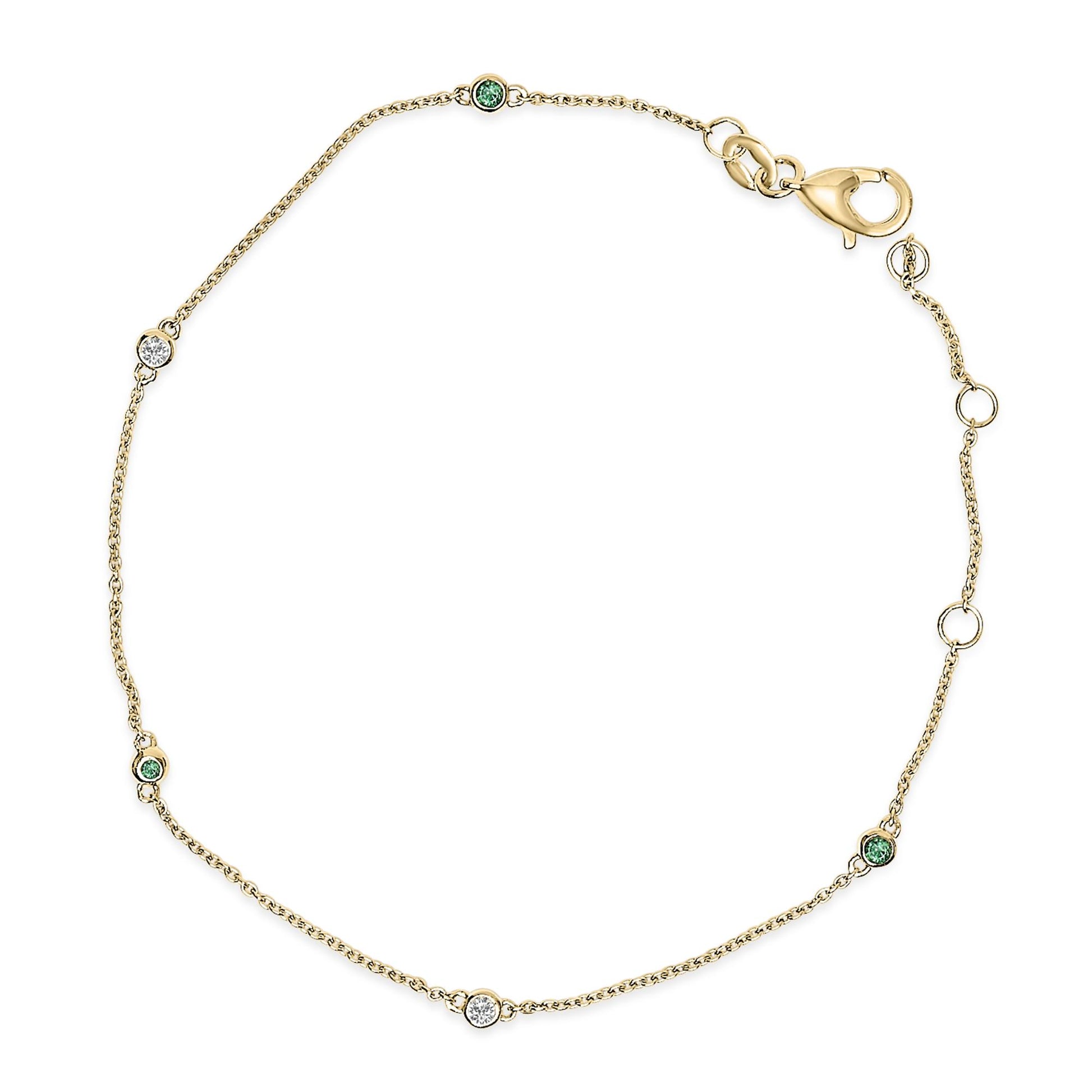 Yellow metal bracelet with round white and green gemstones in bezel settings, shown flat from above.