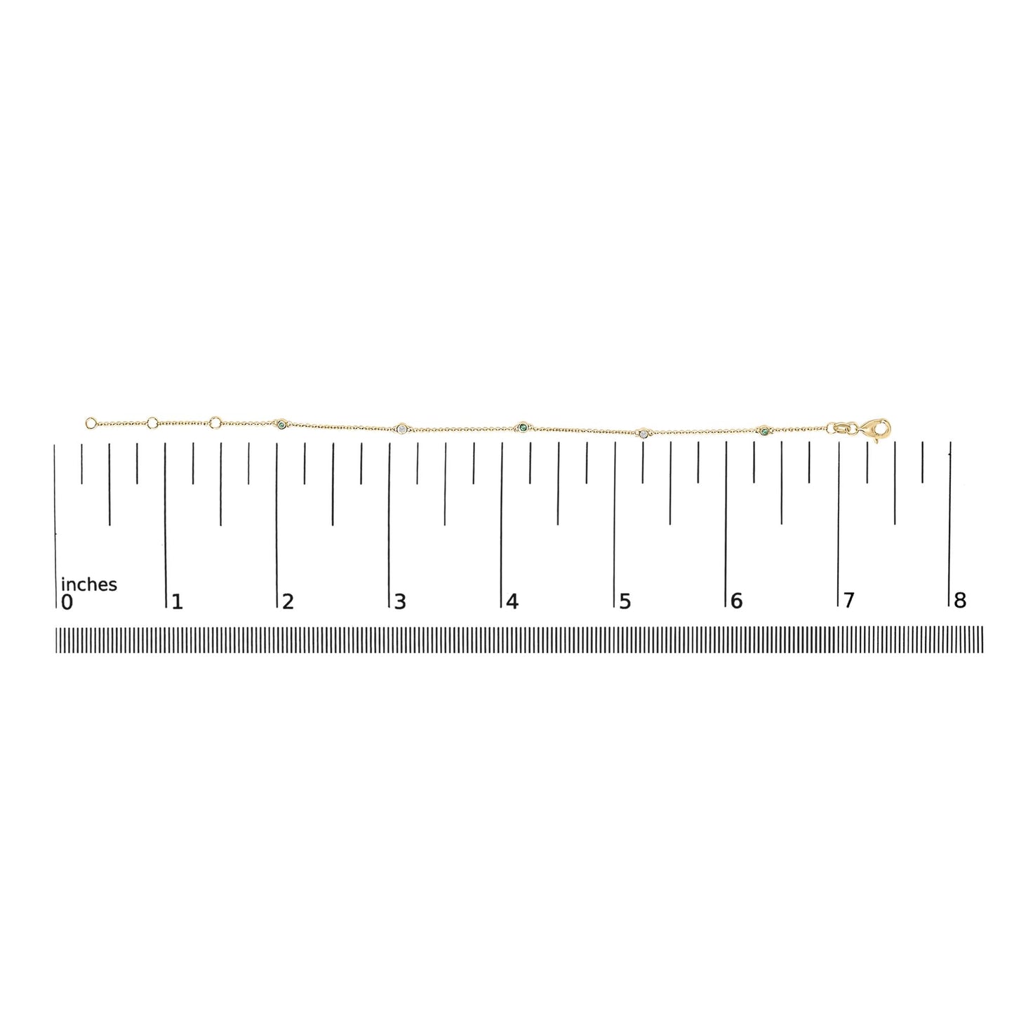 Yellow metal bracelet with round white and green gemstones in bezel settings, shown on a flat surface with a measurement scale, top-down view.