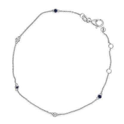 White bracelet with a delicate chain featuring round blue and white gemstones set in bezels, shown flat on a white background from a top-down angle.