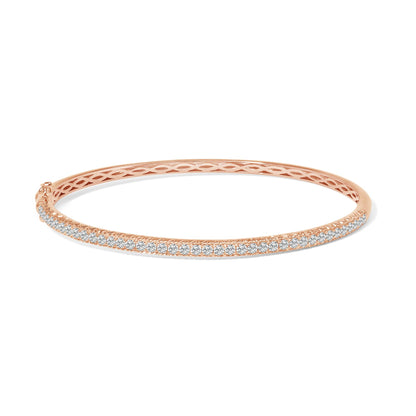 Rose metal bracelet with a row of white round gemstones in pave setting, shown from a side angle on a white background.