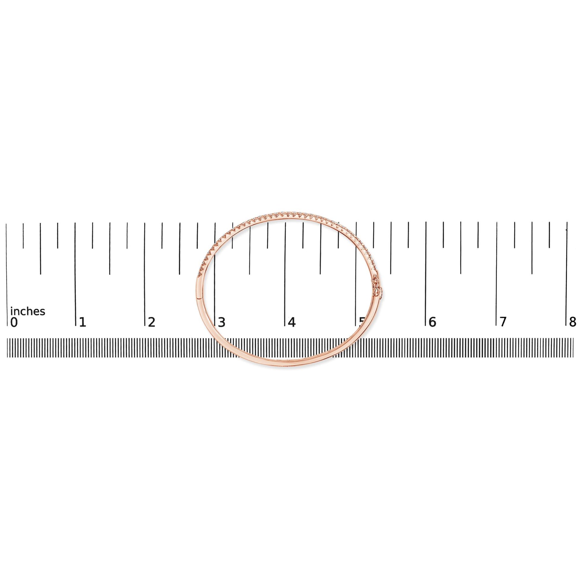 Rose metal bracelet with white gemstones in pave setting, shown flat on a ruler for size reference, top-down angle.