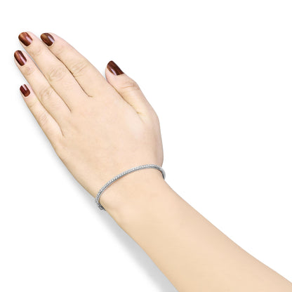 White metal bracelet with pave white round gemstones, shown on a model's wrist from a top angle.