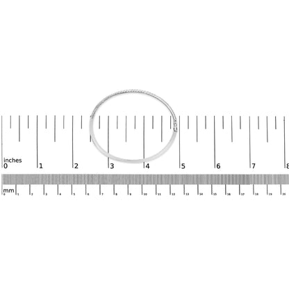 White metal bracelet with round pave-set white gemstones, shown flat on a ruler for size reference, top-down angle.