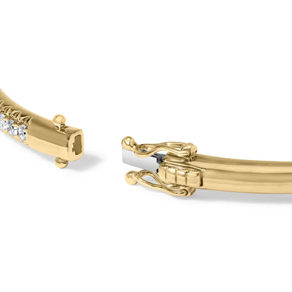 Close-up angled view of a yellow bracelet with round white gemstones in a pave setting and a box clasp partially open.