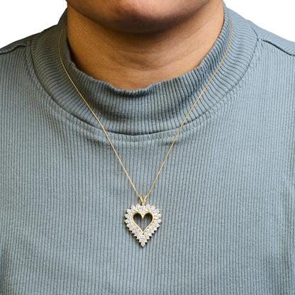 Front view of a yellow metal heart-shaped necklace pendant surrounded by round prong-set brownish gemstones, worn on a model with a blue ribbed top.