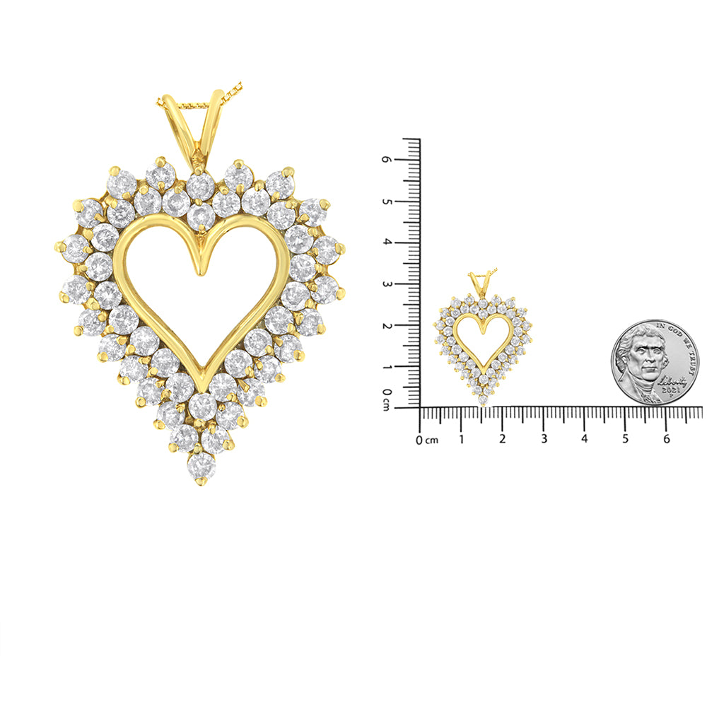 Front-facing shot of a yellow heart-shaped necklace pendant with round brownish prong-set gemstones surrounding the open heart outline, shown next to a ruler and coin for size reference.