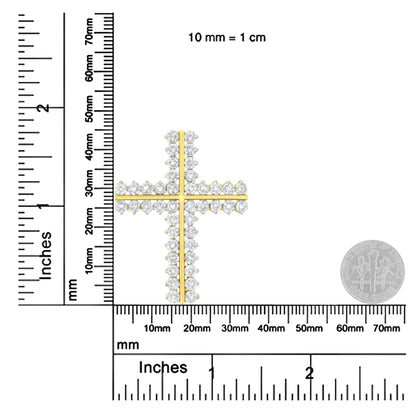Close-up image of a yellow metal cross-shaped necklace pendant adorned with round white gemstones in prong settings, shown on a ruler and scale for size reference.