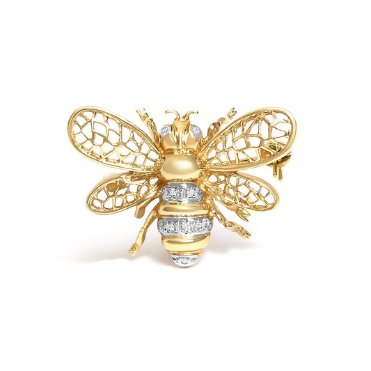 Close-up front view of a yellow and white metal bee-shaped brooch with openwork wings and white gemstones on the eyes and body.
