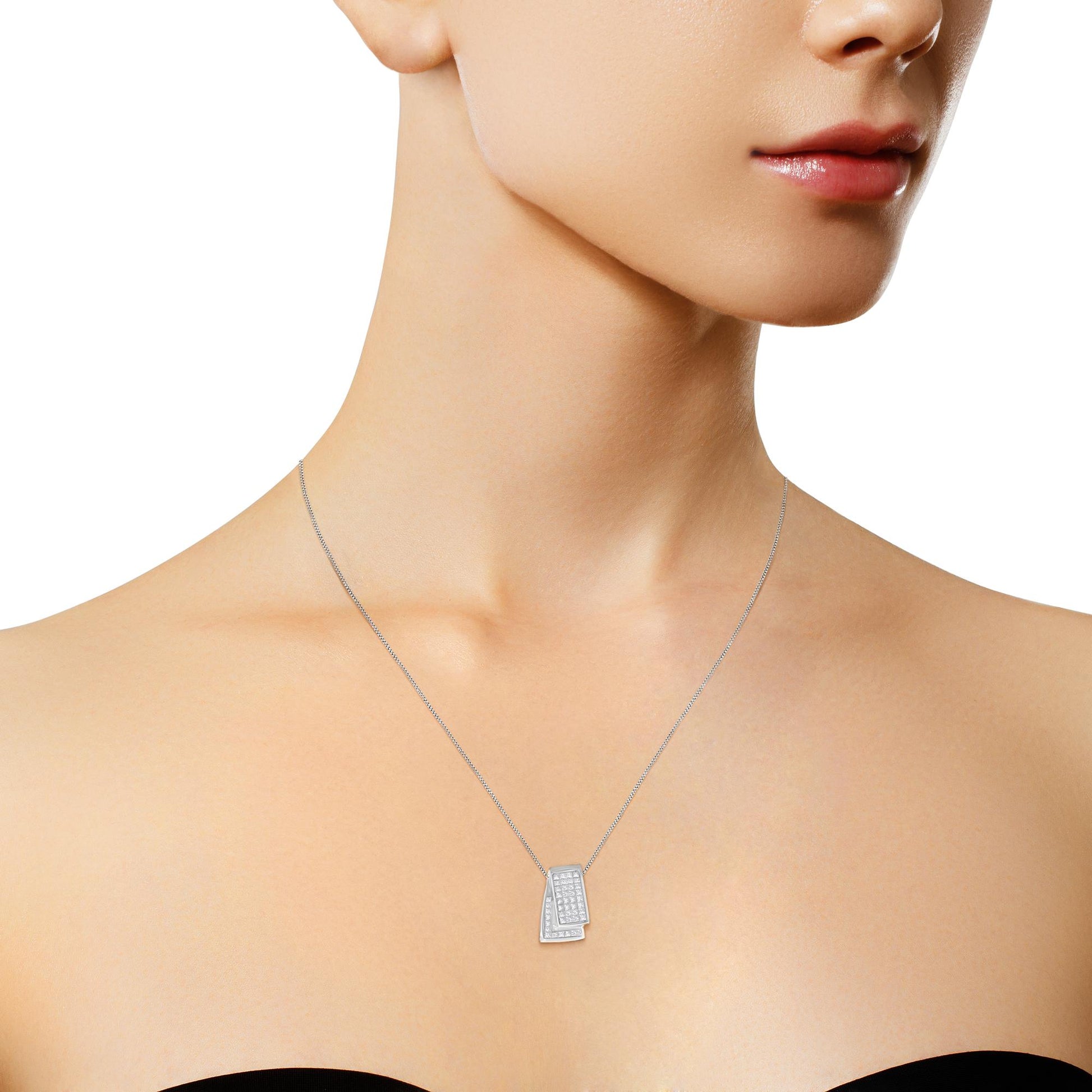 Close-up of a model wearing a white metal necklace with a pendant featuring two overlapping rectangular shapes adorned with multiple small white gemstones in an invisible setting, shot from the front.