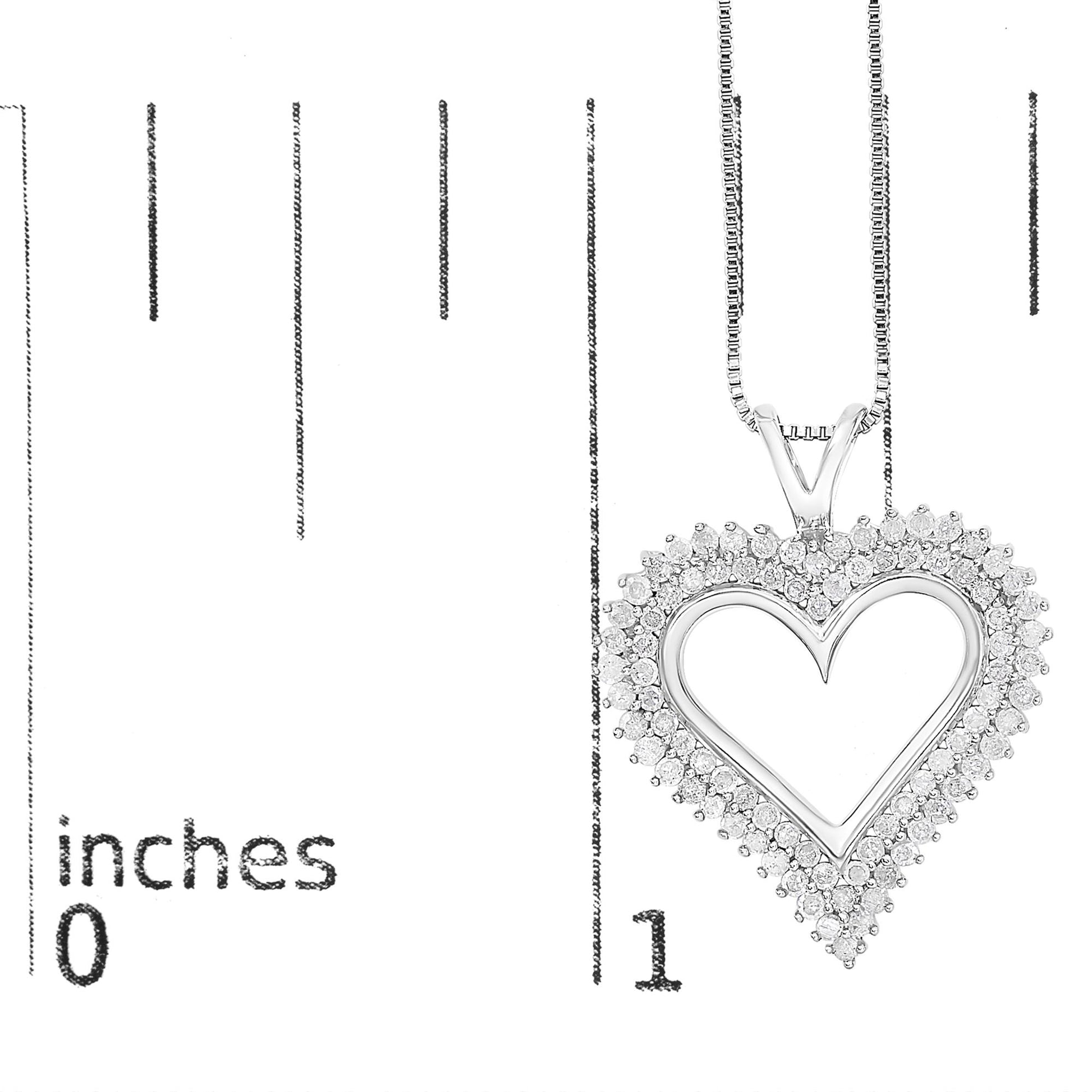 Close-up front view of a white metal heart-shaped necklace pendant with round white gemstones in prong settings, shown on a ruler for size reference.
