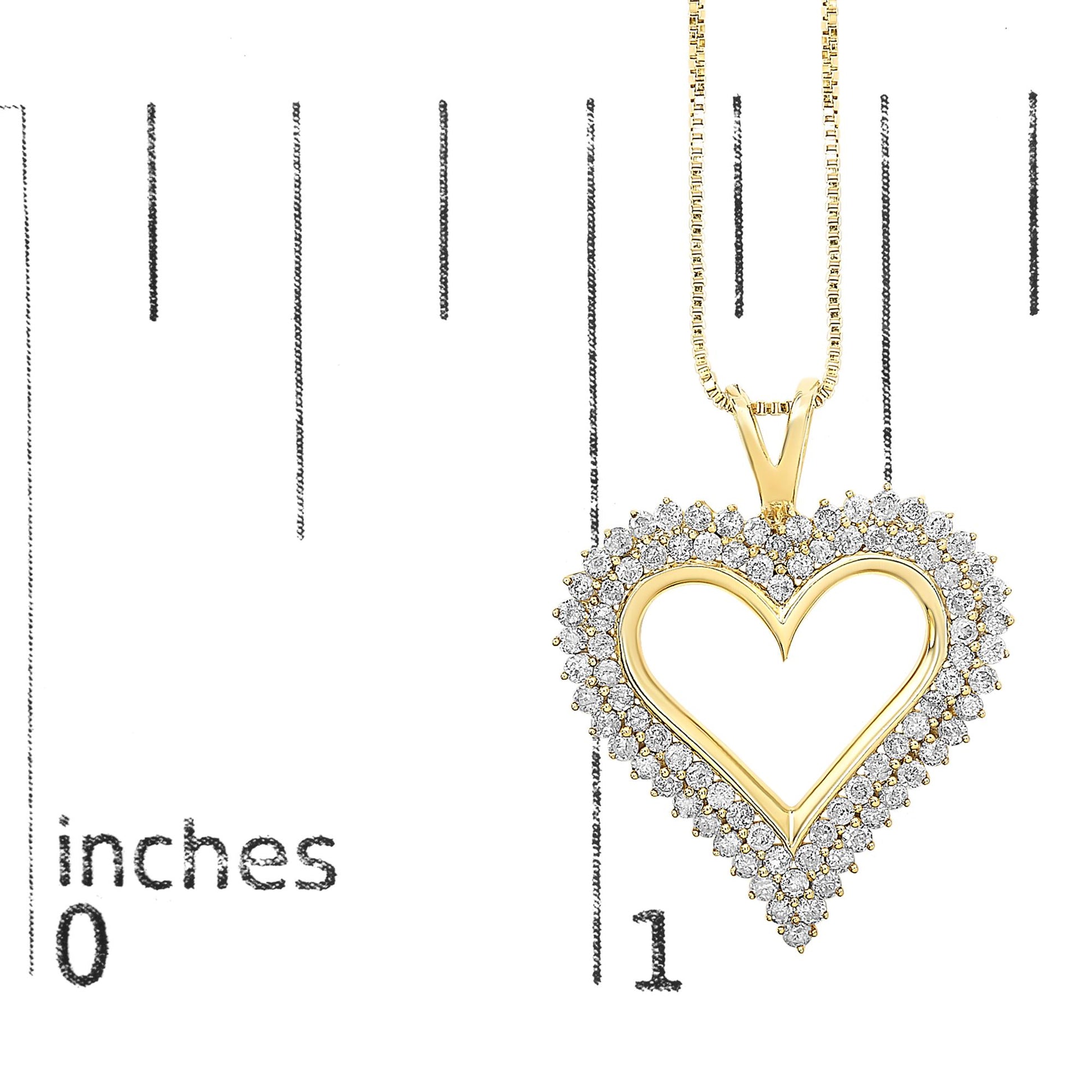 Yellow metal heart-shaped necklace pendant with round white gemstones surrounding the outline, shown front-facing on a ruler for size reference.