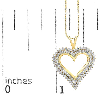 Yellow metal heart-shaped necklace pendant with round white gemstones surrounding the outline, shown front-facing on a ruler for size reference.