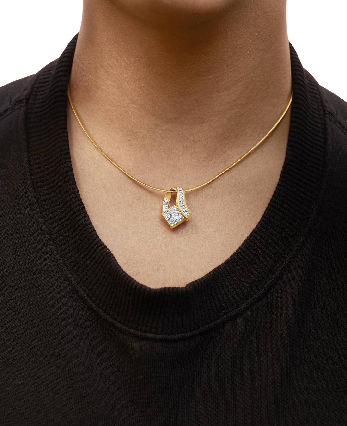 Close-up front view of a necklace worn on a model featuring a yellow metal chain with a pendant that has white baguette-shaped gemstones in channel setting and white princess-shaped gemstones in invisible setting.