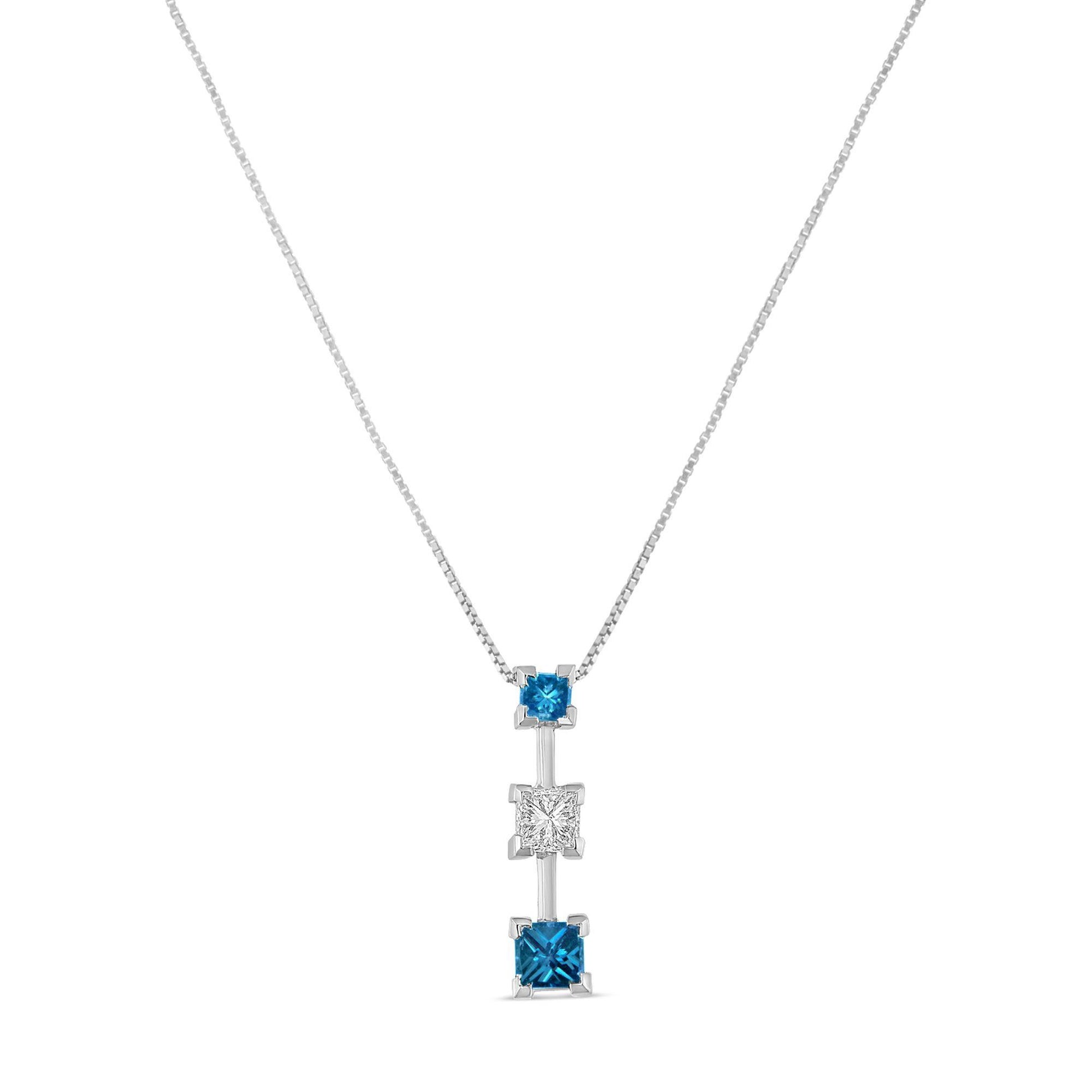 Front view of a white necklace with a vertical pendant featuring three princess-shaped prong-set gemstones, two blue and one white in the center.