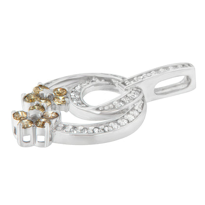 White metal necklace pendant with intertwined oval shapes, set with round white gemstones along the curves and clusters of round champagne gemstones at one end, shown in a close-up angled view.