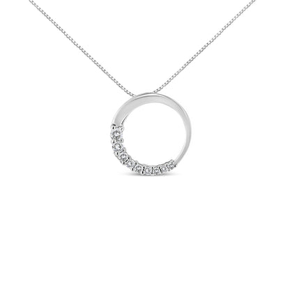 Front angle view of a white metal circular pendant necklace with half of the circle adorned with round white gemstones in prong settings.