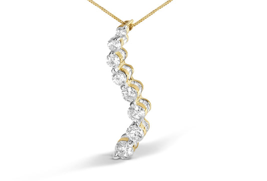Yellow metal necklace pendant with alternating round white gemstones in prong settings and baguette white gemstones in channel settings, shown from a side angle.