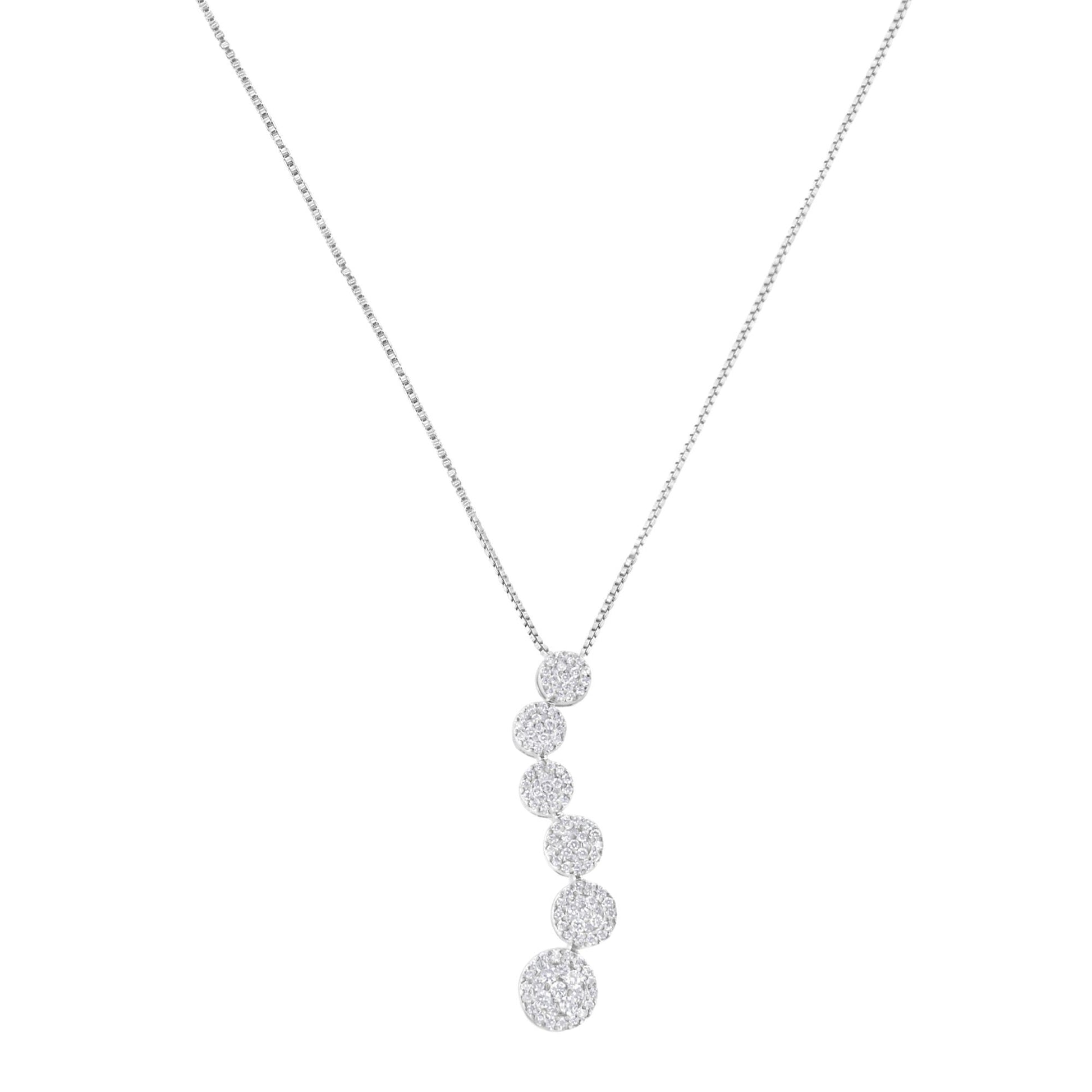 Front view of a white necklace with a vertical pendant composed of multiple round shapes each paved with white gemstones.