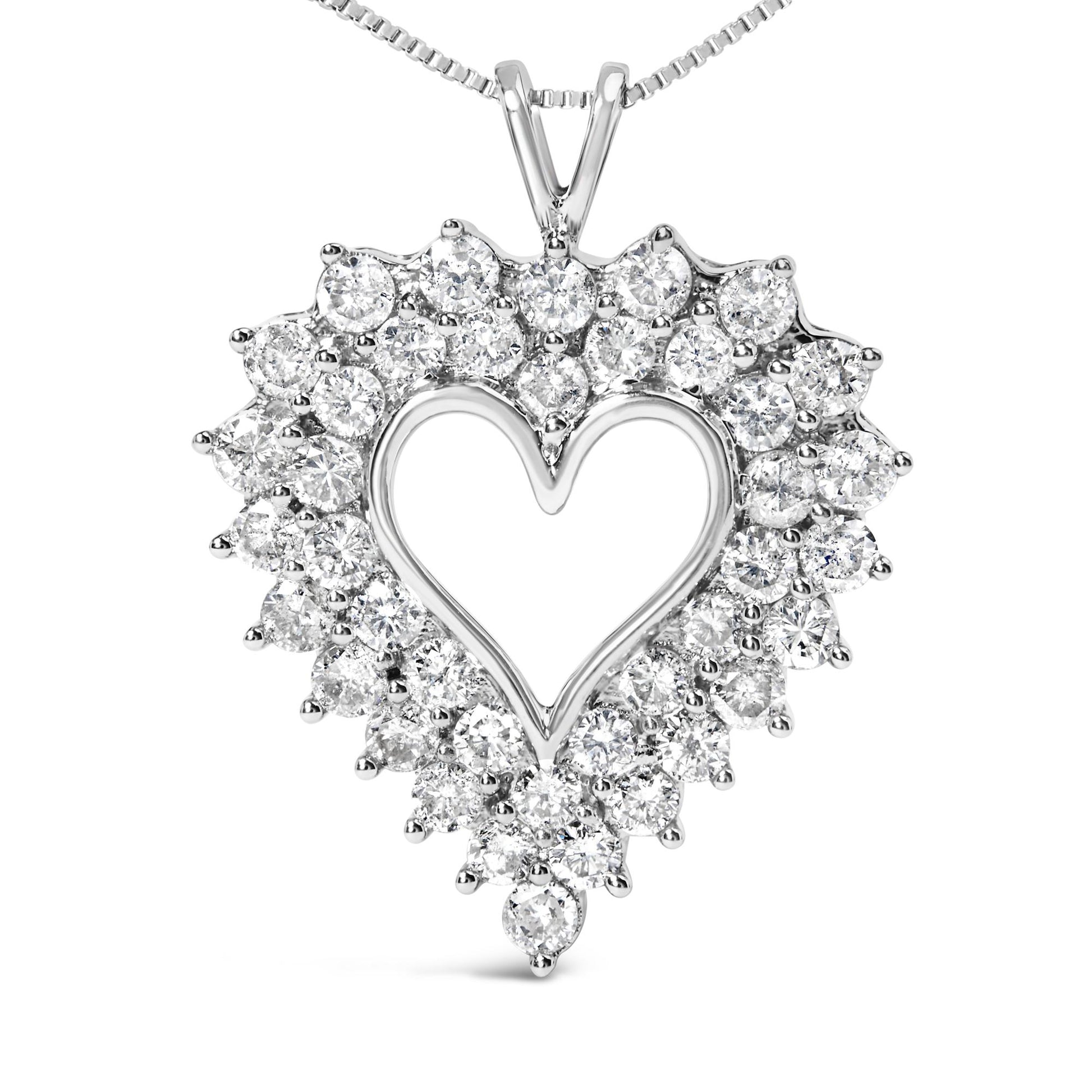 Front-facing view of a white metal heart-shaped necklace pendant adorned with round white gemstones in prong settings around the outline, with baguette white gemstones in channel settings forming the inner design.
