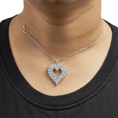 Close-up front view of a white metal heart-shaped pendant necklace with round white gemstones in prong settings surrounding the open heart center, worn on a model.