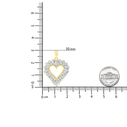 Top-down view of a yellow metal heart-shaped necklace pendant with round brownish gemstones in prong and channel settings, placed on a ruler with a coin for size reference.