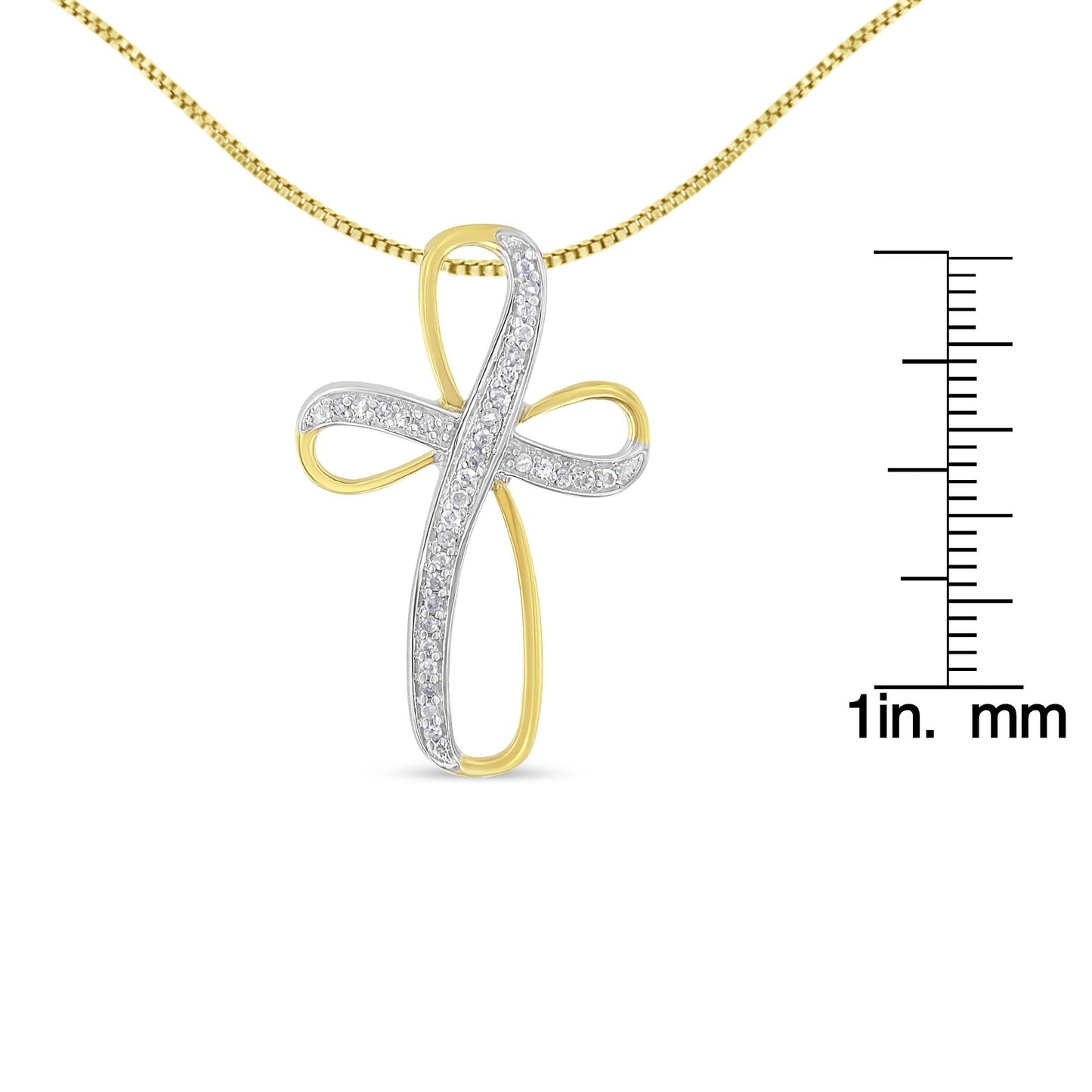 Front view of a yellow and white metal cross-shaped necklace pendant with white gemstones in a pave setting, displayed next to a ruler for size reference.