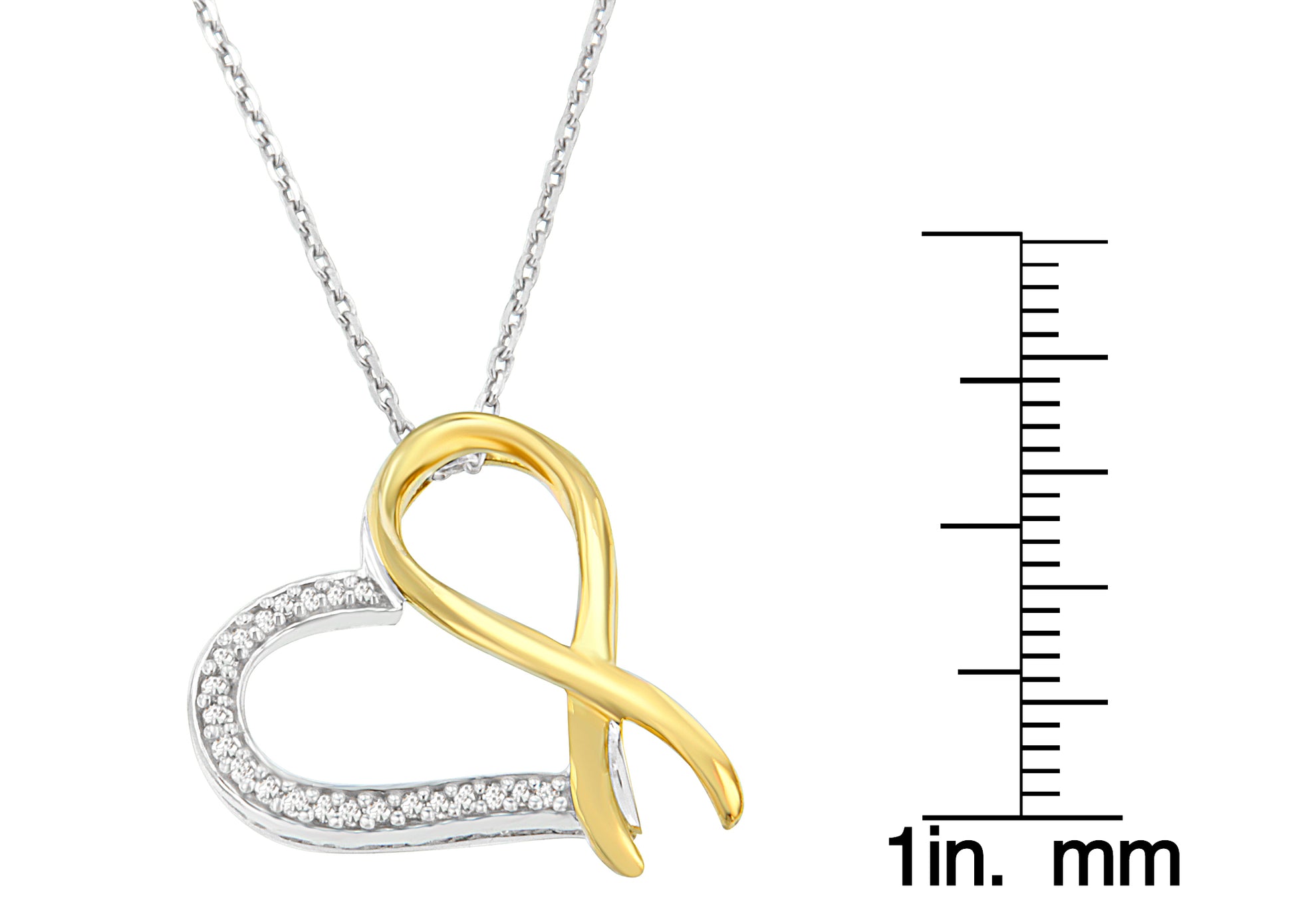 Close-up front view of a two-toned heart-shaped necklace pendant with an intertwined loop design, featuring round white gemstones in prong settings along one side, displayed next to a ruler for size reference.