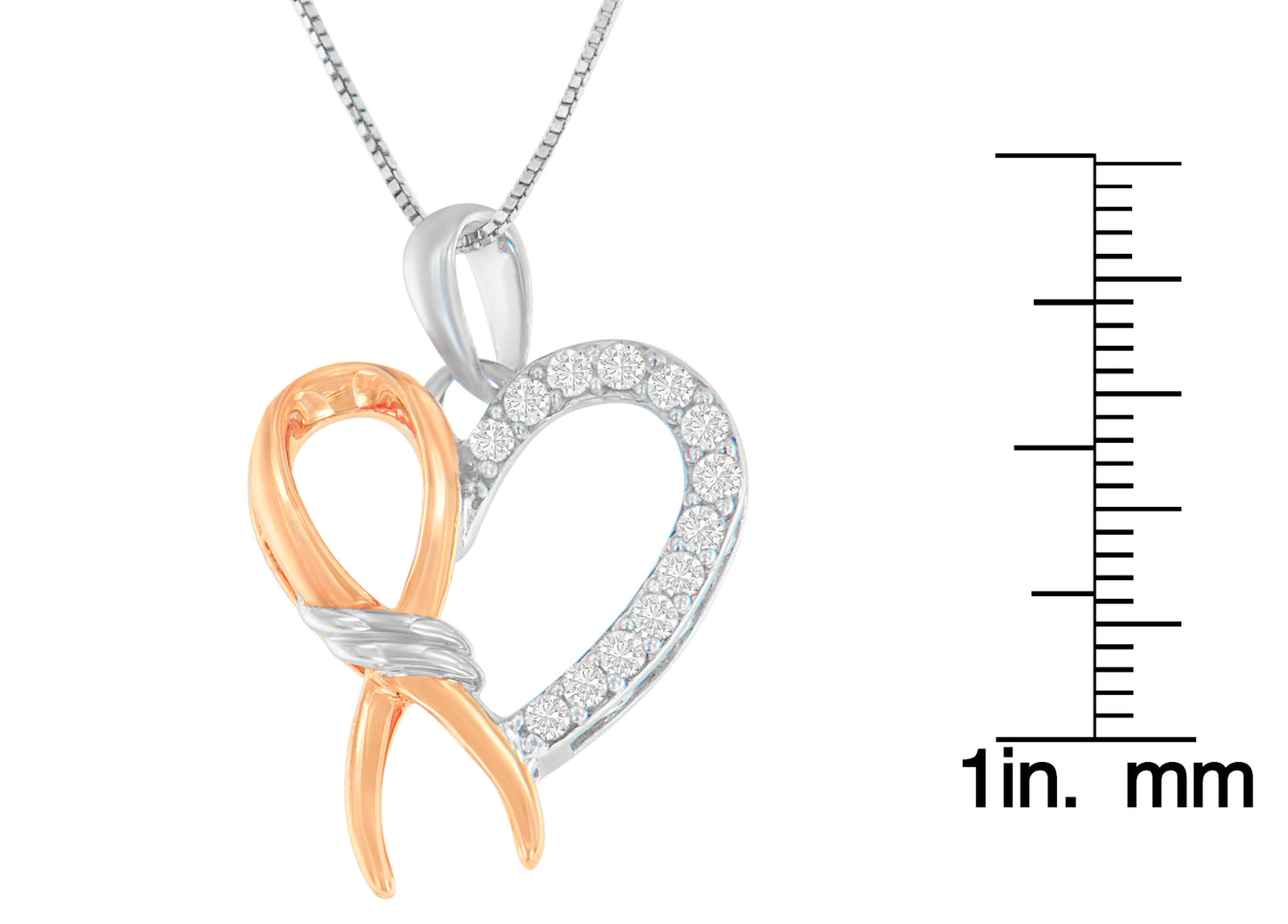 Two-toned necklace pendant in heart shape with one side featuring white gemstones in prong setting, shown in a close-up front angle, displayed next to a ruler for size reference.