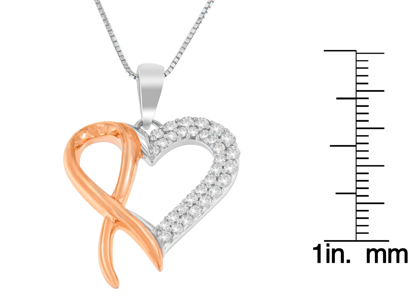 Close-up front angle of a yellow and white metal heart-shaped necklace pendant with round white gemstones on one side, shown next to a ruler for size reference.