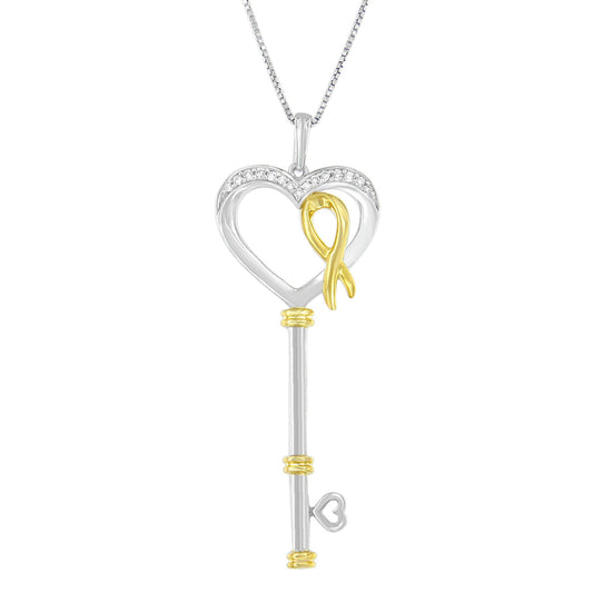 Front-facing image of a two-toned necklace pendant in the shape of a key with a heart-shaped top adorned with white round gemstones in prong settings and a gold ribbon detail.