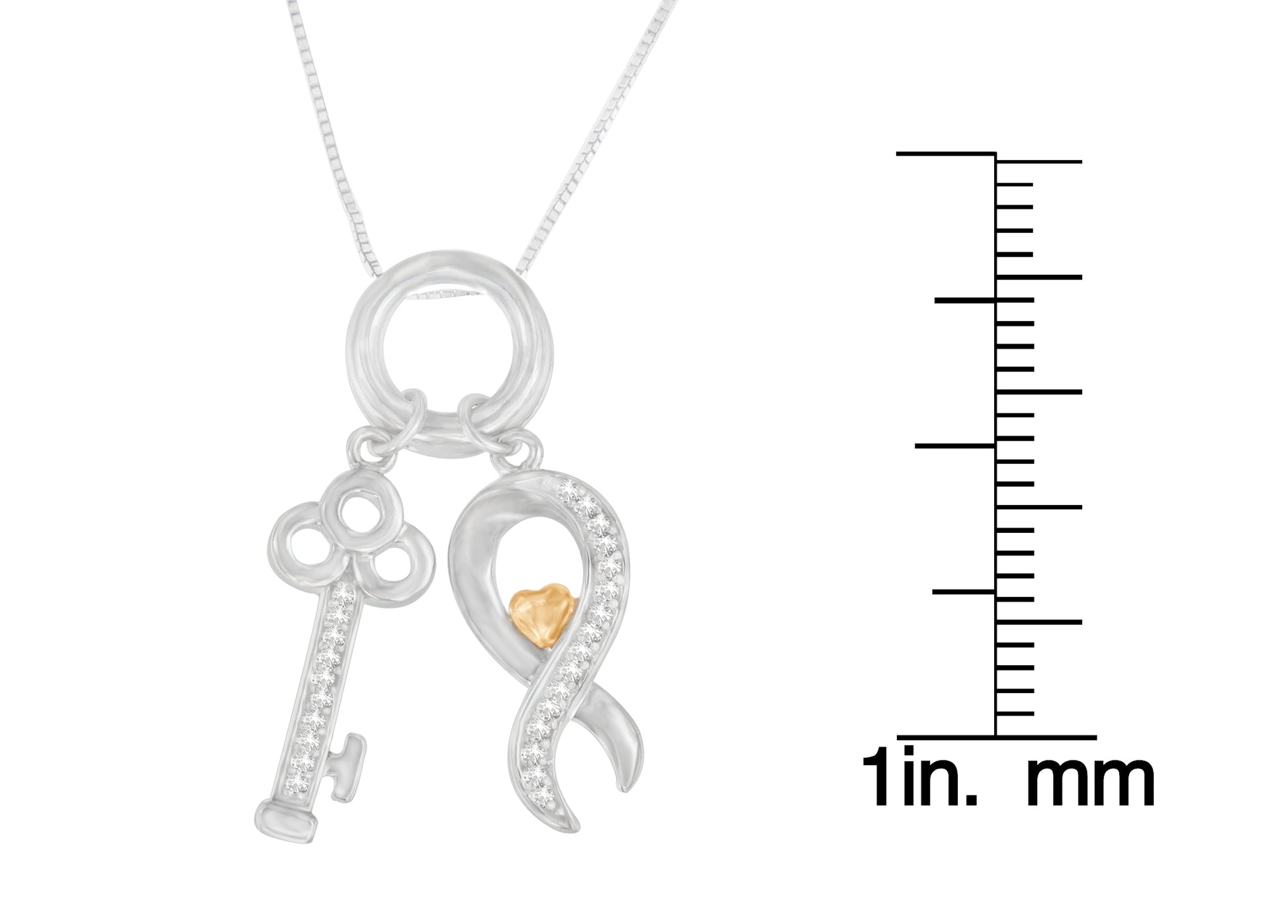 Close-up front view of a two-tone necklace with silver key and ribbon-shaped pendants adorned with round white gemstones, shown next to a scale for size reference.