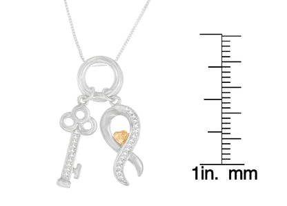 Close-up front view of a two-tone necklace with silver key and ribbon-shaped pendants adorned with round white gemstones, shown next to a scale for size reference.