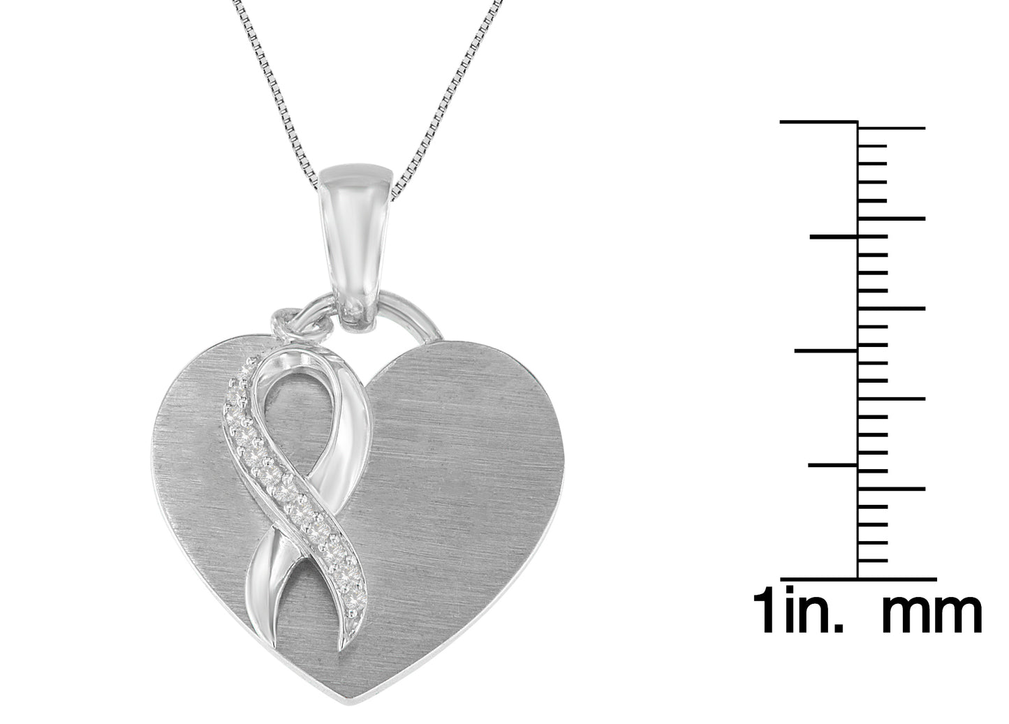 Close-up front view of a white metal heart-shaped necklace pendant with an infinity design on the front, partially set with round white gemstones, shown next to a ruler for size reference.