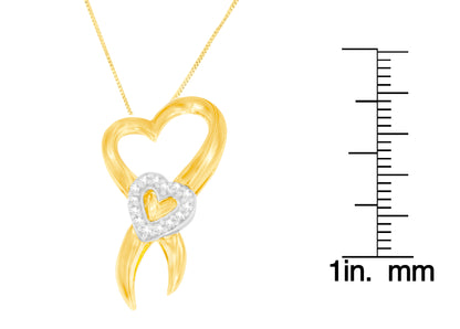 Close-up front view of a yellow and white metal heart-shaped necklace pendant with small white gemstones in prong settings on the white metal heart, shown with a ruler for size reference.