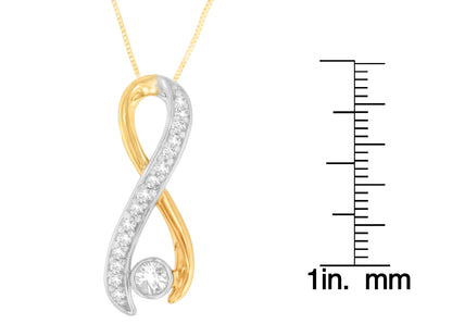 Front view of a yellow and white metal necklace pendant with a twisting design featuring multiple white round gemstones in prong settings, shown next to a ruler for size reference.