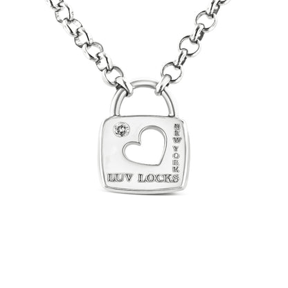 Close-up front view of a white metal necklace with a padlock-shaped pendant featuring a heart-shaped cutout, a round white gemstone in bezel setting, and engraved text 'LUV LOCKS' and 'NEW YORK'.