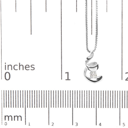 Close-up of a white metal necklace with a curved abstract pendant holding a round white gemstone, displayed on a ruler for size reference.