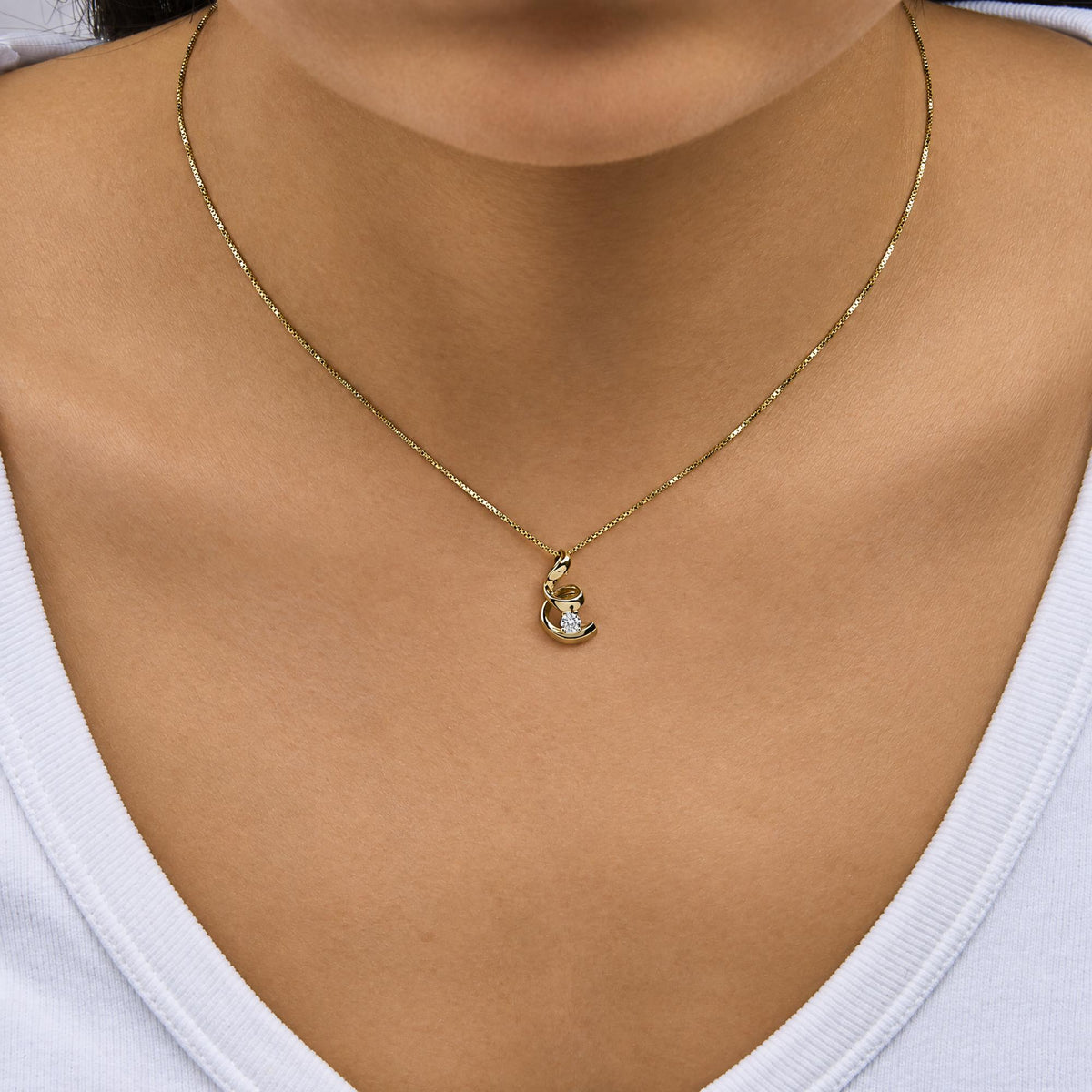 10K yellow gold spiral diamond pendant necklace shown on a model