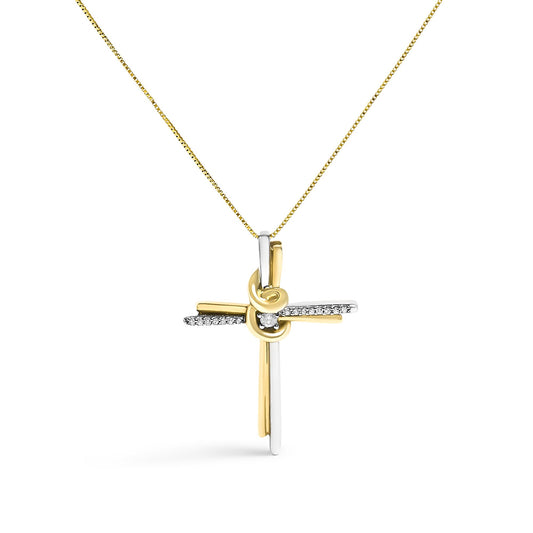 Front-facing shot of a two-toned cross necklace pendant with a knot detail at the center, adorned with one round white gemstone in the middle and a row of small round white gemstones along the horizontal bar, hanging from a chain.